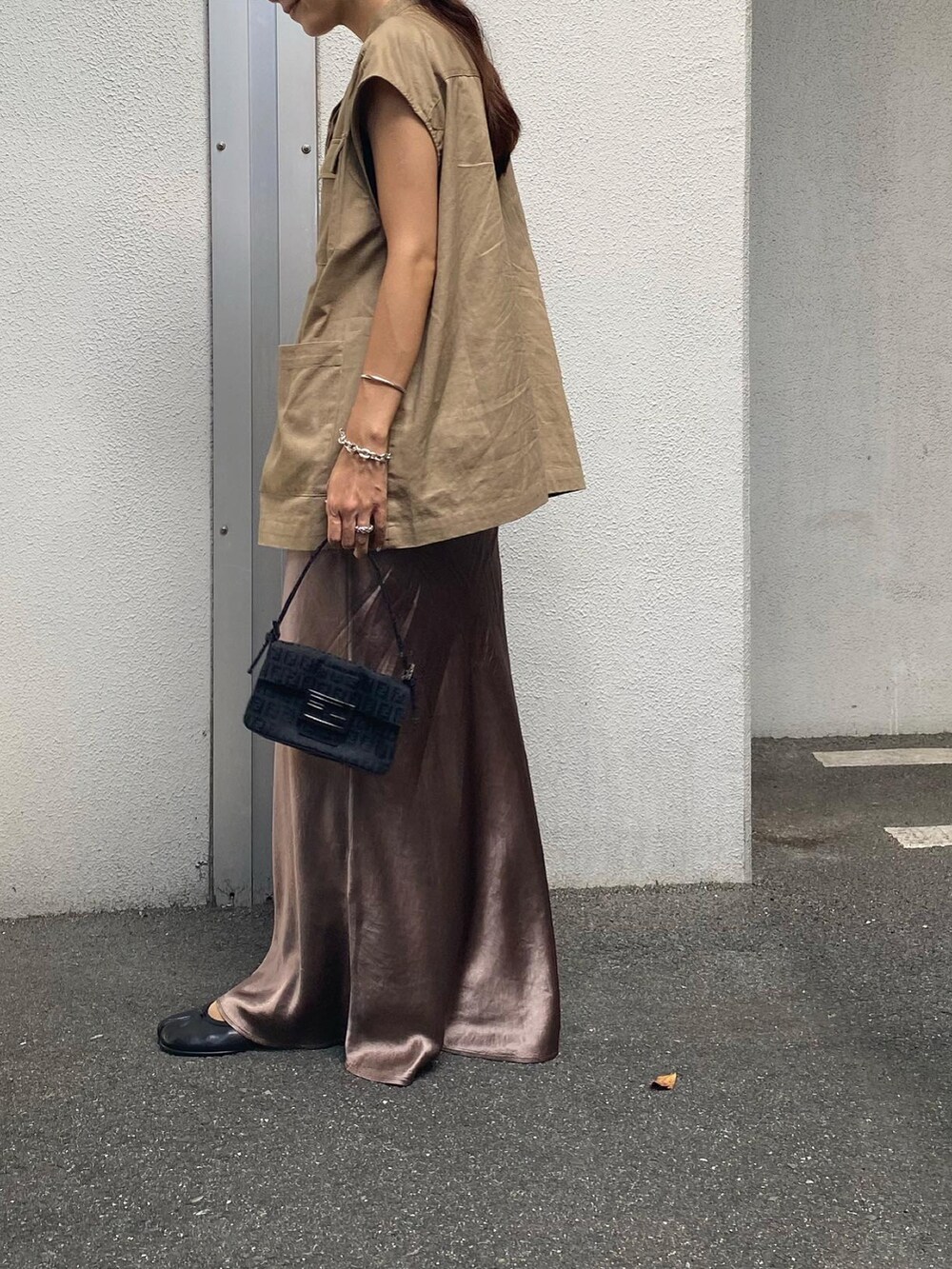 ベージュ系のベスト、ブラウン系のスカート、ブラック系のバレエシューズを着用したレディースの秋コーディネートの3枚目の写真