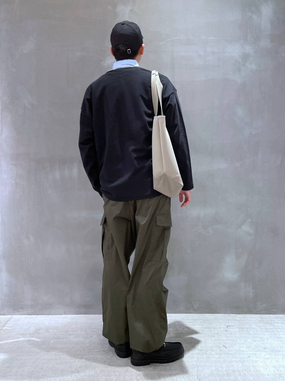 ブラック系のカーディガン/ボレロ、ブラック系のローファー、グリーン系のカーゴパンツを着用したメンズの冬コーディネートの3枚目の写真