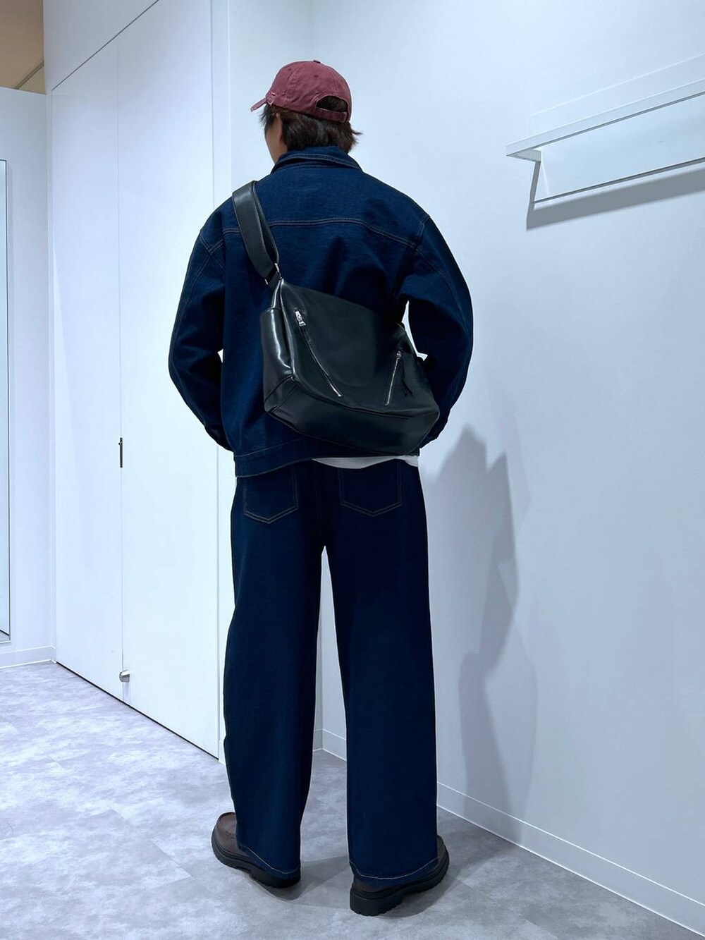 グレー系のニット/セーター、ブラウン系のローファー、ブラック系のショルダーバッグを着用したメンズの冬コーディネートの3枚目の写真