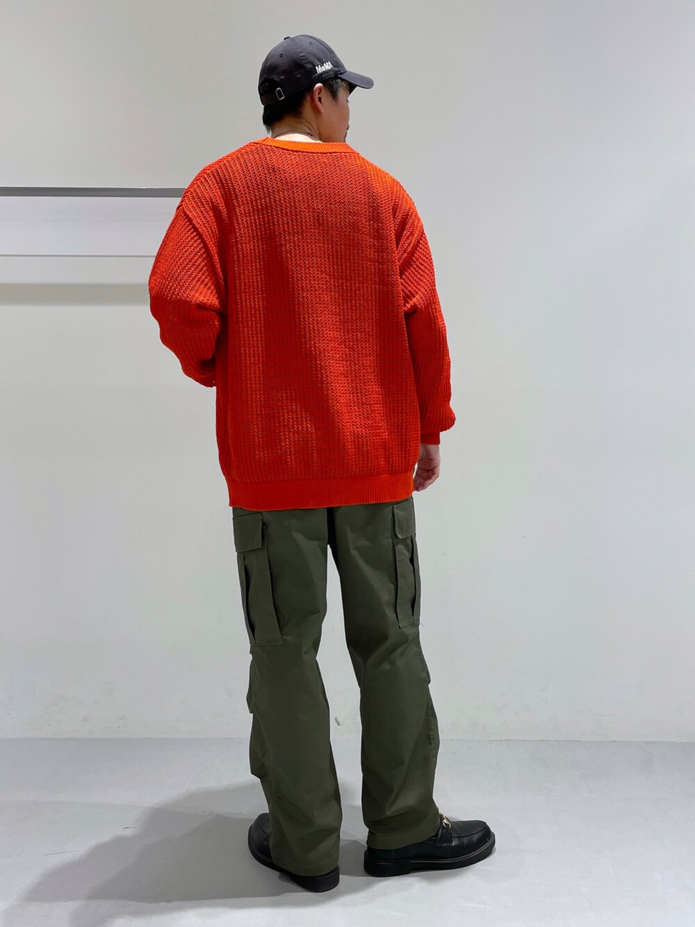 オレンジ系のカーディガン/ボレロ、ベージュ系のTシャツ/カットソー、ブラック系のローファーを着用したメンズの冬コーディネートの3枚目の写真