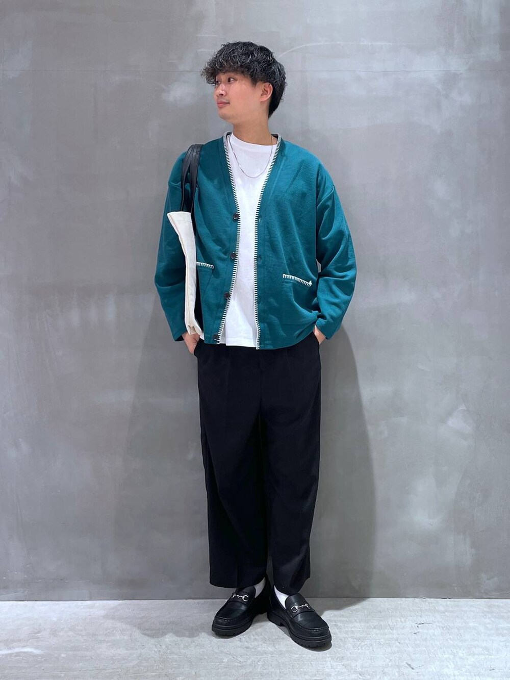 ベージュ系のトートバッグ、ホワイト系のTシャツ/カットソー、グリーン系のカーディガン/ボレロを着用したメンズの春コーディネートの2枚目の写真
