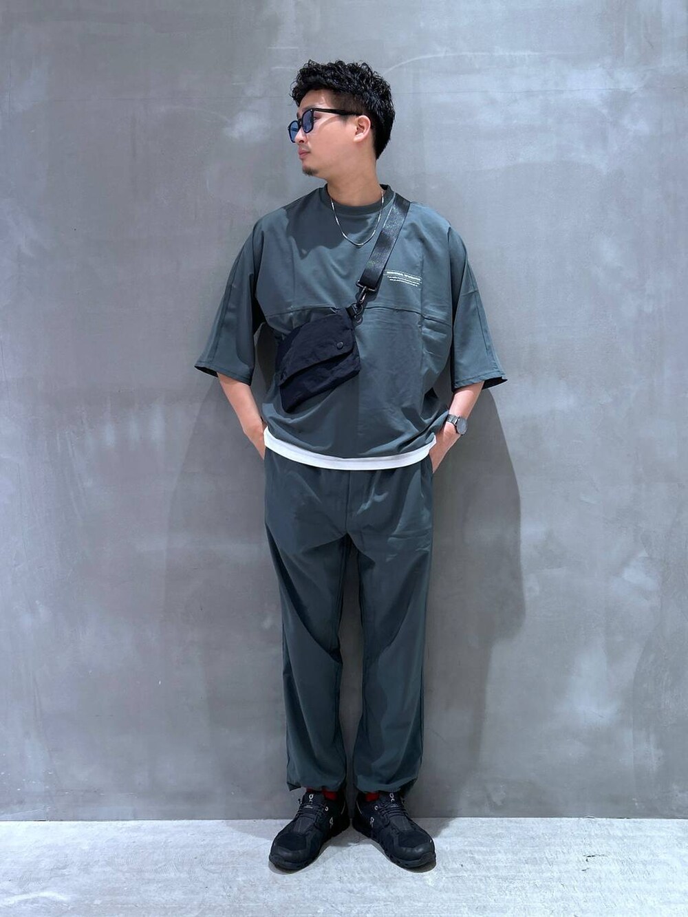 ブラック系のショルダーバッグ、ホワイト系のTシャツ/カットソー、グリーン系のTシャツ/カットソーを着用したメンズの夏コーディネートの4枚目の写真