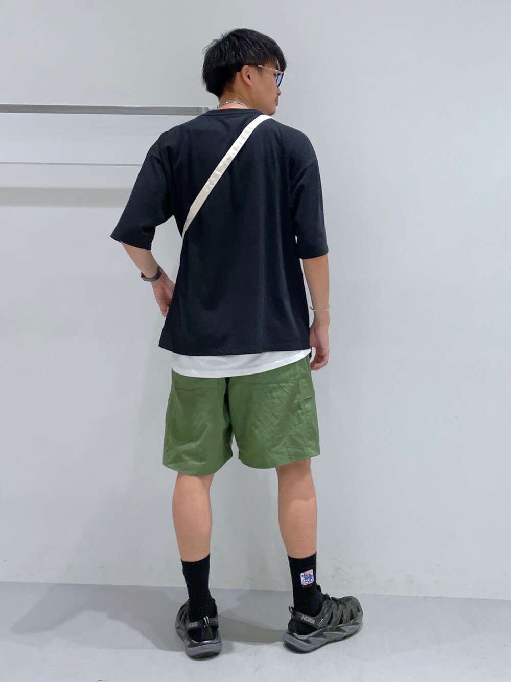 グリーン系のカーゴパンツ、ブラック系のTシャツ/カットソー、その他のショルダーバッグを着用したメンズの夏コーディネートの3枚目の写真