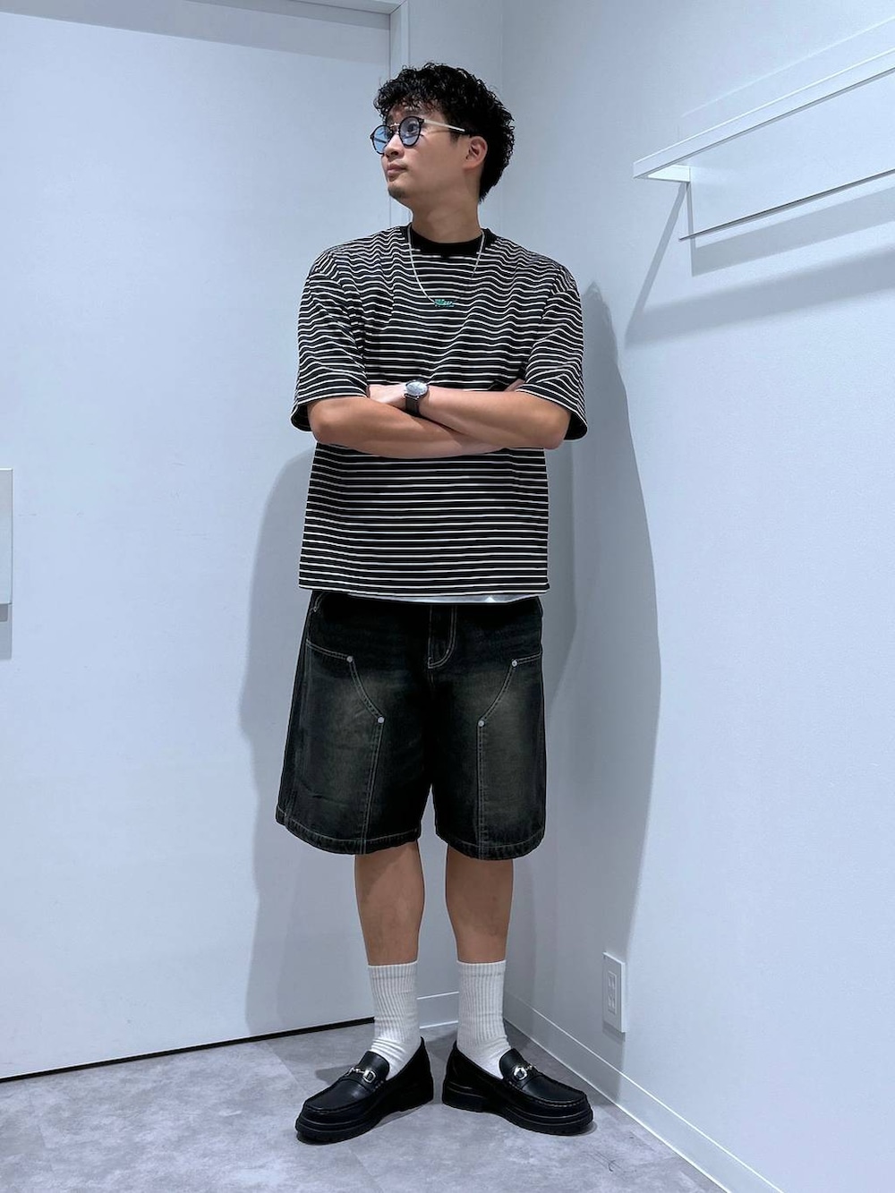 ブラック系のローファー、ブラック系のデニムパンツ、その他のTシャツ/カットソーを着用したメンズの春コーディネートの2枚目の写真