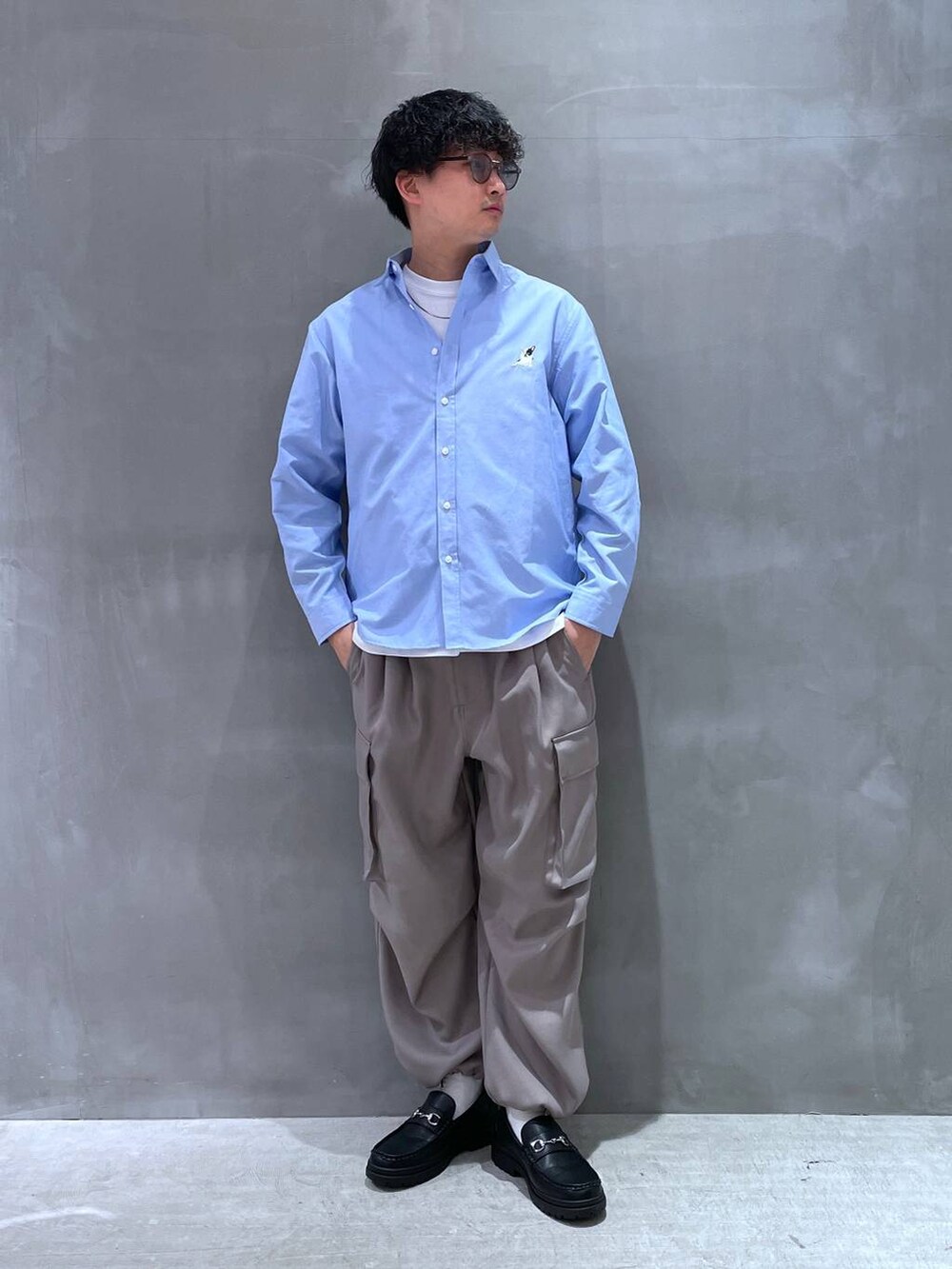 ホワイト系のTシャツ/カットソー、ブラック系のローファー、グレー系のカーゴパンツを着用したメンズの春コーディネートの5枚目の写真