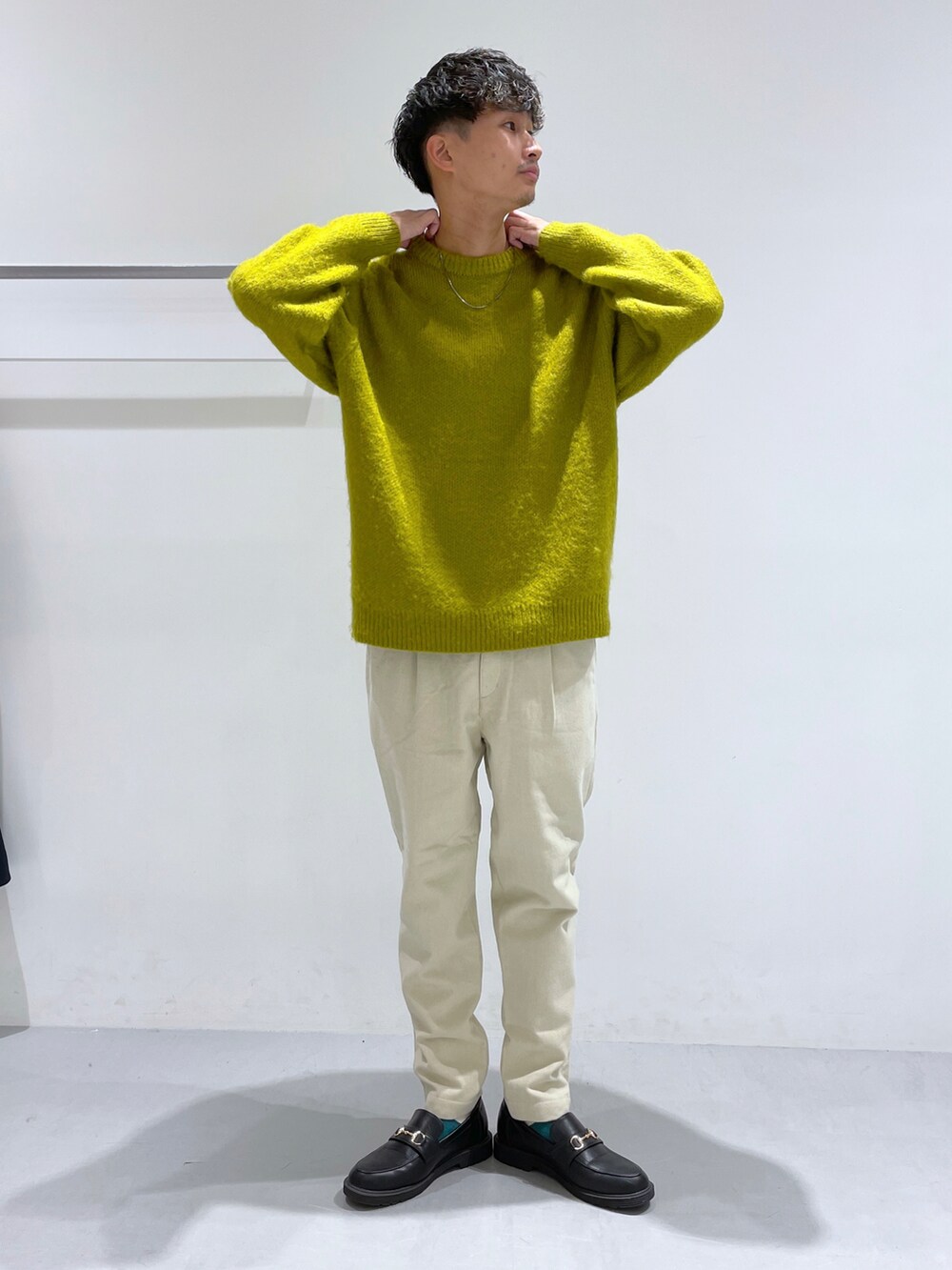 ホワイト系のその他パンツ、ブラック系のローファー、イエロー系のニット/セーターを着用したメンズの冬コーディネートの2枚目の写真