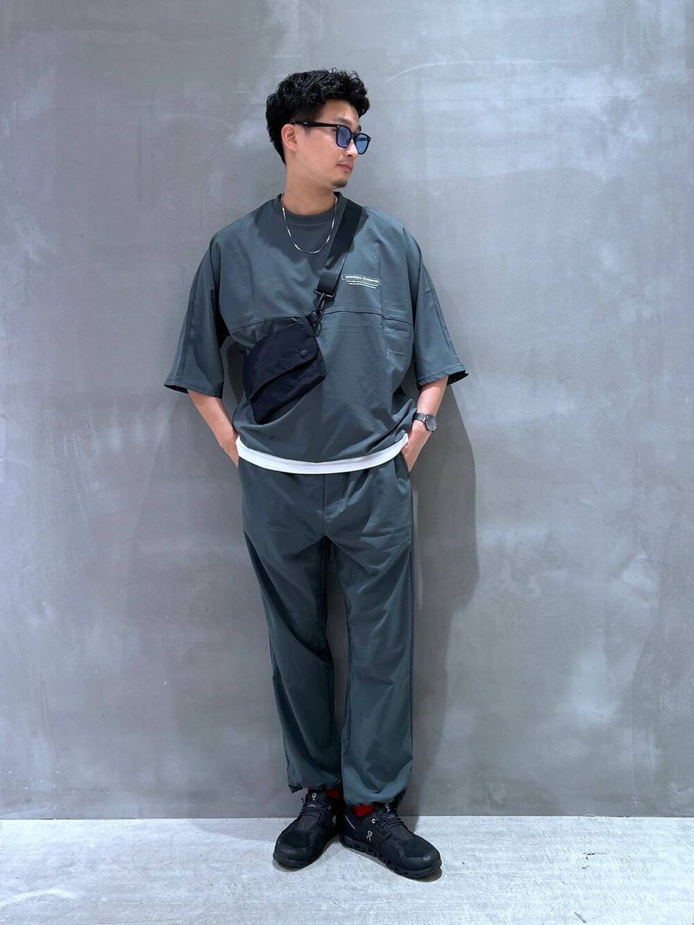 ブラック系のショルダーバッグ、ホワイト系のTシャツ/カットソー、グリーン系のTシャツ/カットソーを着用したメンズの夏コーディネートの3枚目の写真