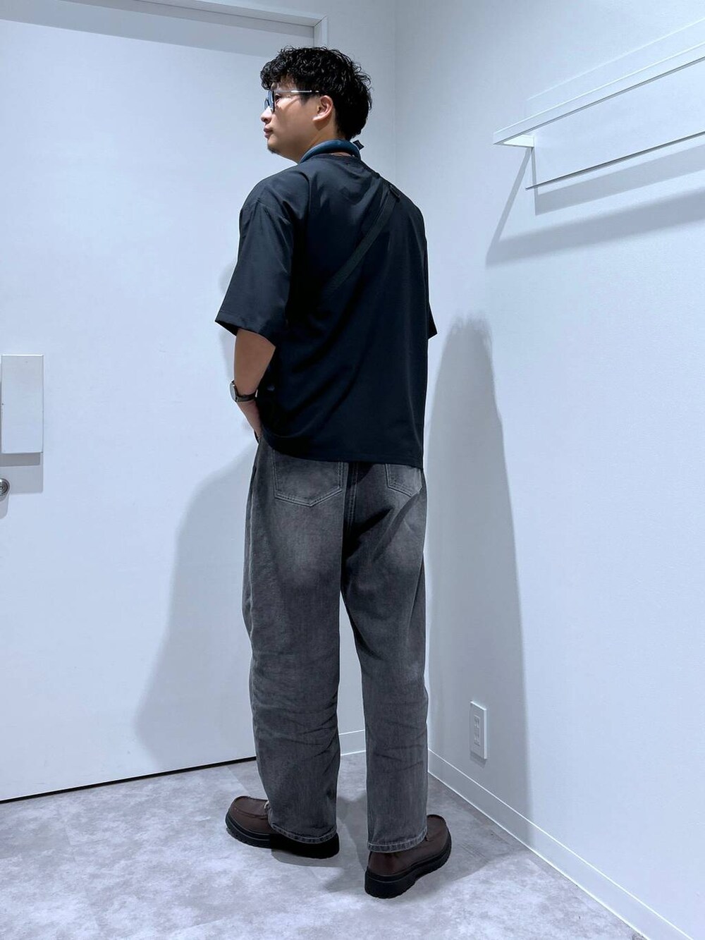 グレー系のデニムパンツ、ブラウン系のローファー、パープル系のショルダーバッグを着用したメンズの春コーディネートの3枚目の写真