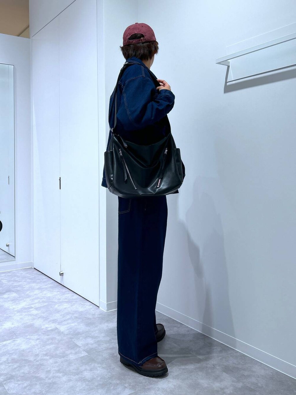 グレー系のニット/セーター、ブラウン系のローファー、ブラック系のショルダーバッグを着用したメンズの冬コーディネートの4枚目の写真