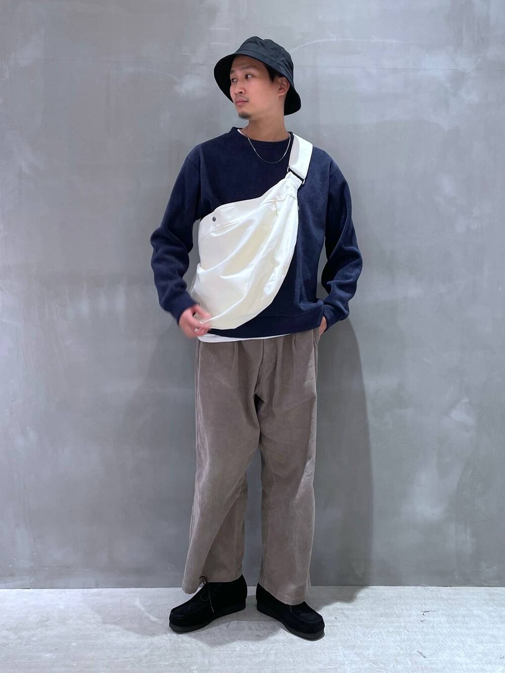 ベージュ系のショルダーバッグ、ベージュ系のその他パンツ、ブラック系のモカシン/デッキシューズを着用したメンズの冬コーディネートの2枚目の写真