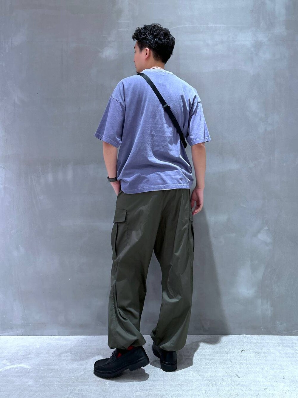 ブラック系のローファー、グリーン系のカーゴパンツ、ブラック系のスマホグッズを着用したメンズの夏コーディネートの3枚目の写真