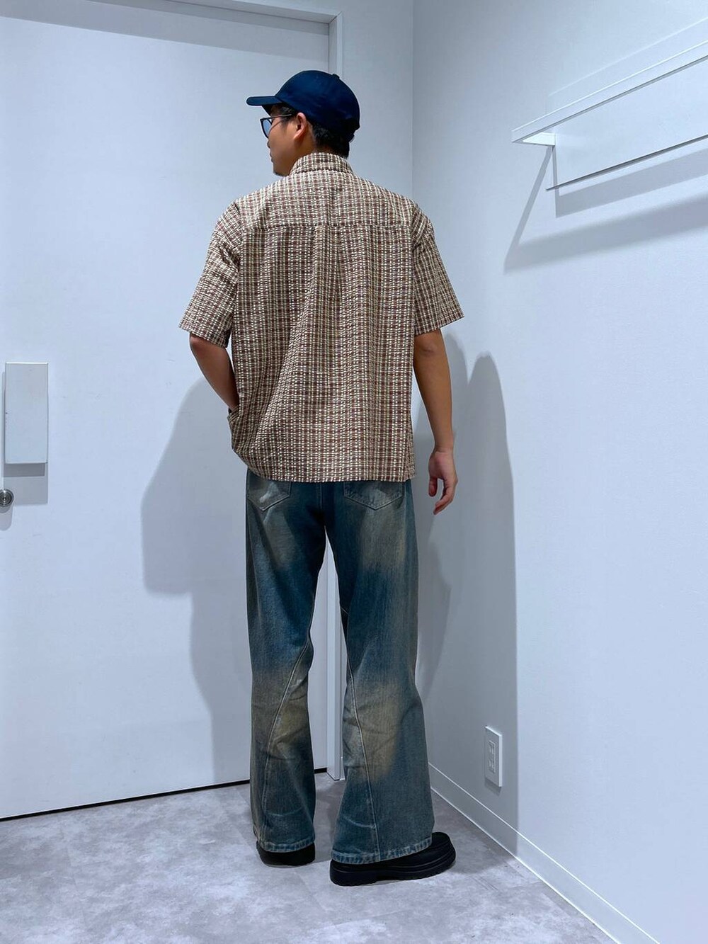 ブルー系のデニムパンツ、ブラック系のローファー、レッド系のシャツ/ブラウスを着用したメンズの春コーディネートの3枚目の写真