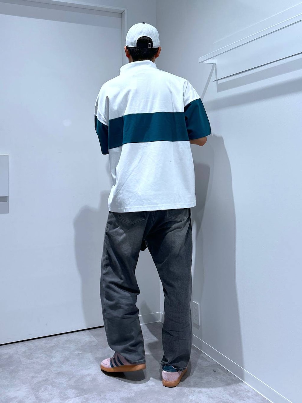 グレー系のデニムパンツ、グリーン系のTシャツ/カットソー、ブラウン系のトートバッグを着用したメンズの春コーディネートの3枚目の写真