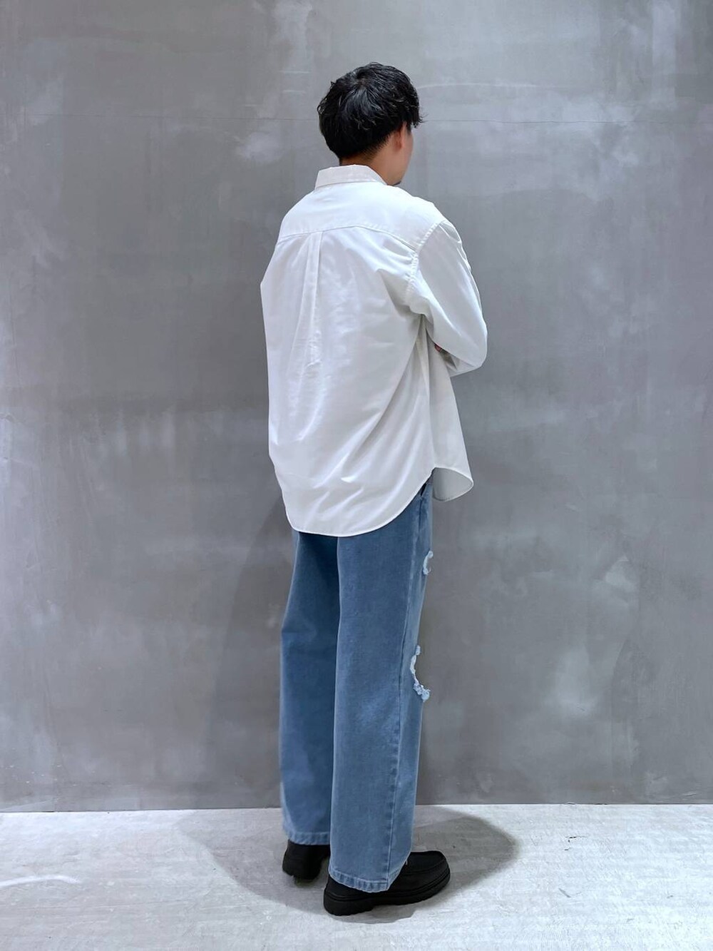 ブラック系のローファー、ブルー系のデニムパンツ、ホワイト系のシャツ/ブラウスを着用したメンズの冬コーディネートの3枚目の写真