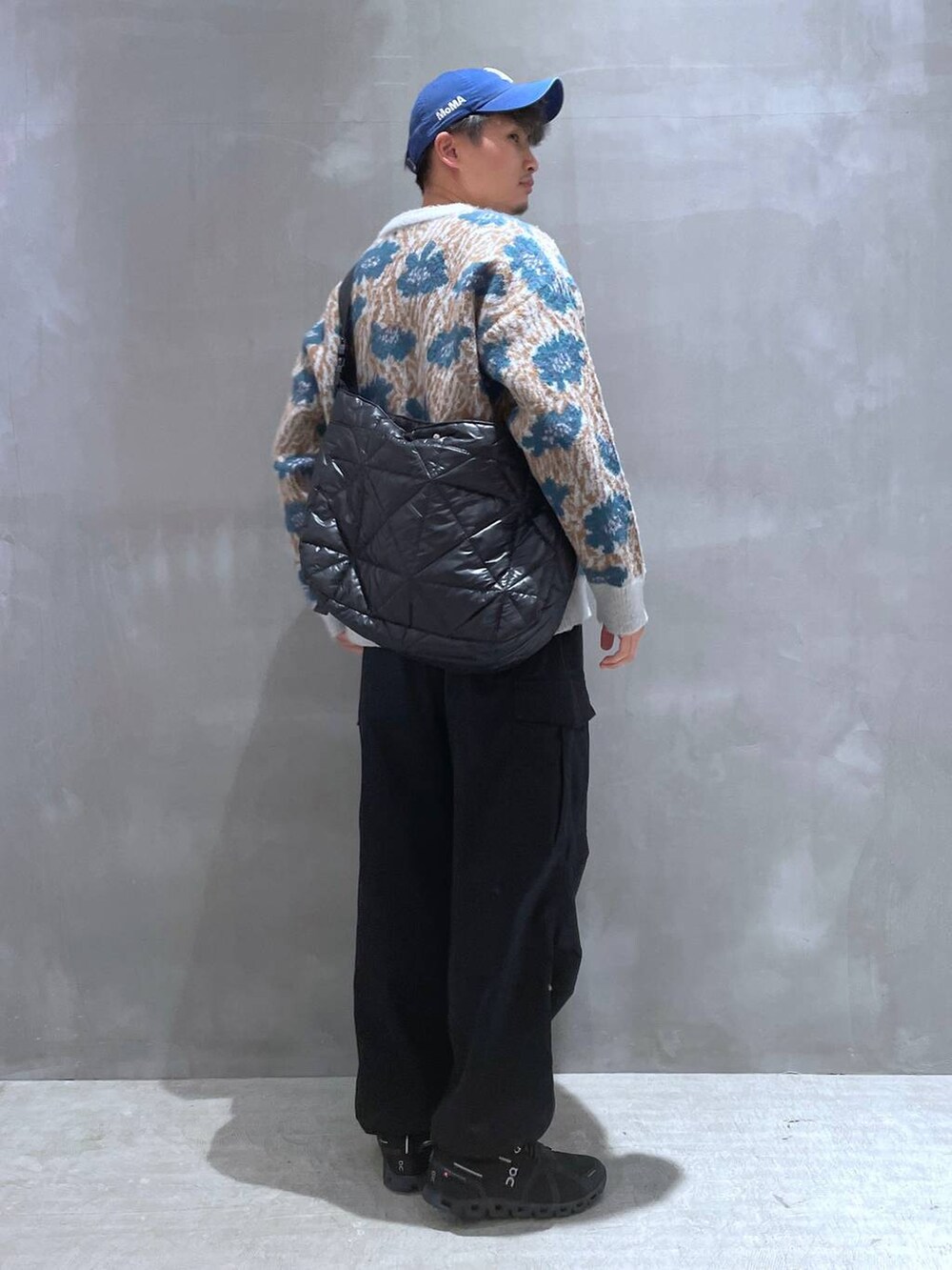 ブルー系のニット/セーター、ブラック系のカーゴパンツ、ブラック系のショルダーバッグを着用したメンズの秋コーディネートの3枚目の写真