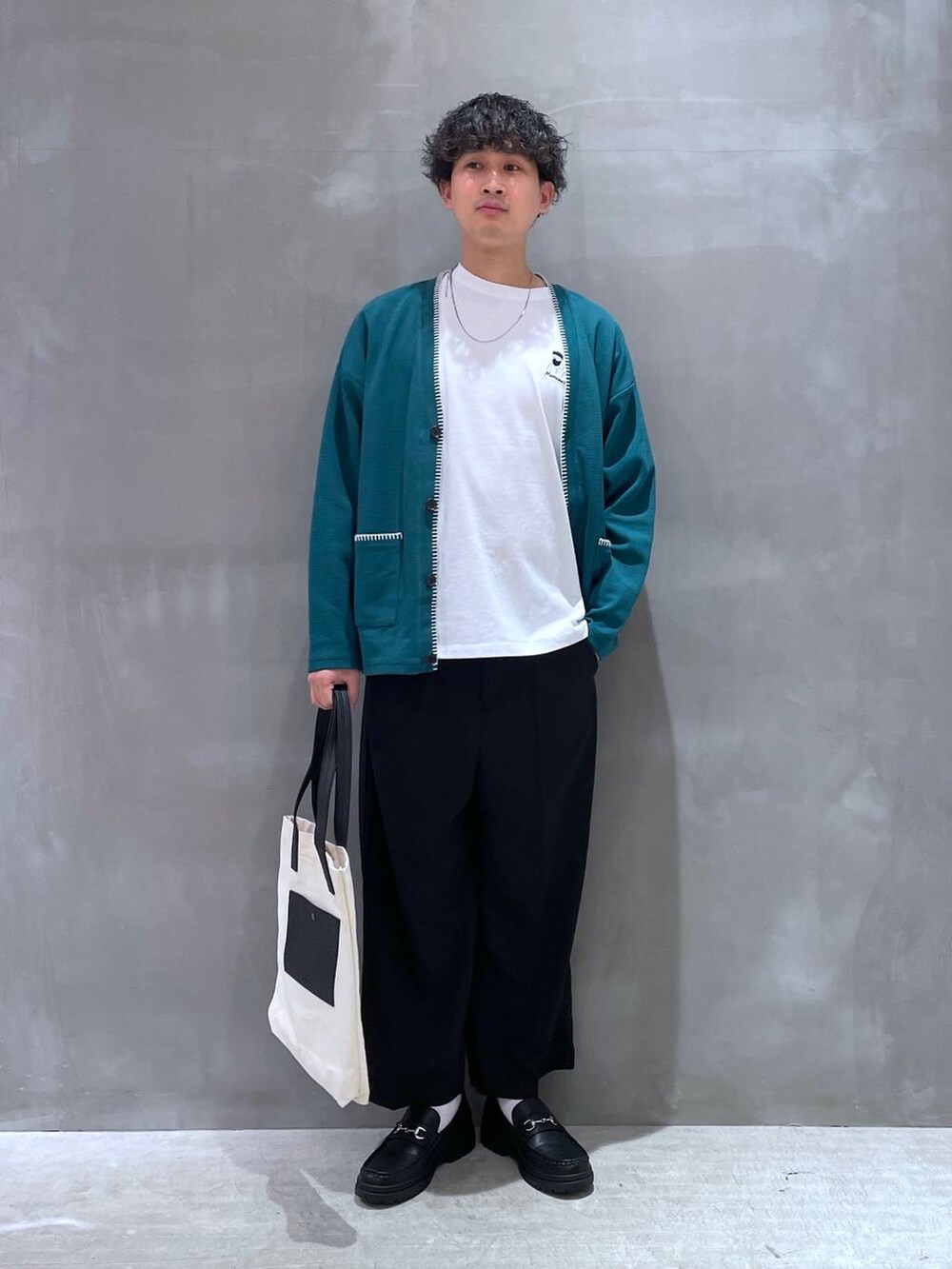 ベージュ系のトートバッグ、ホワイト系のTシャツ/カットソー、グリーン系のカーディガン/ボレロを着用したメンズの春コーディネートの4枚目の写真