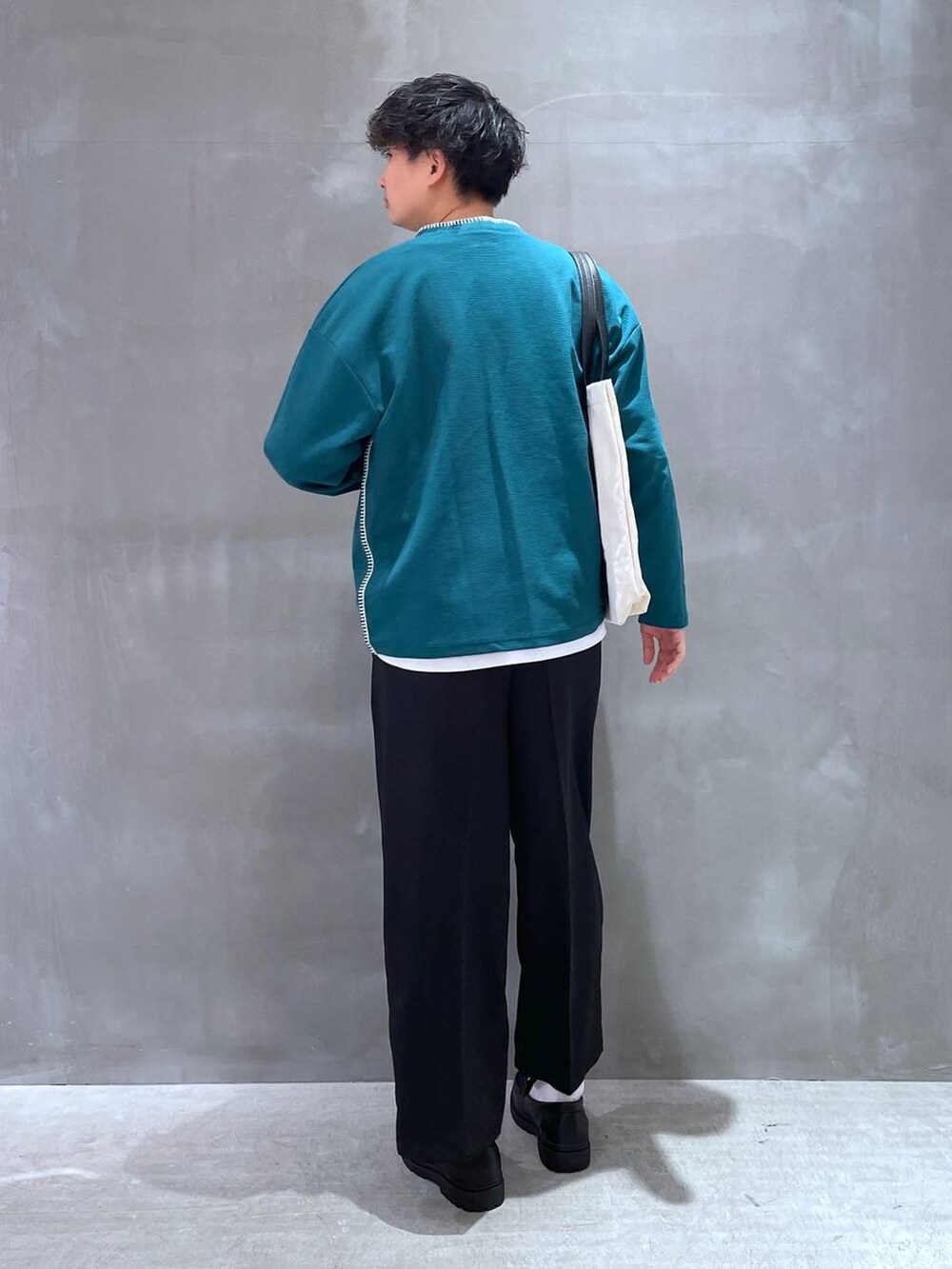 ベージュ系のトートバッグ、ホワイト系のTシャツ/カットソー、グリーン系のカーディガン/ボレロを着用したメンズの春コーディネートの3枚目の写真