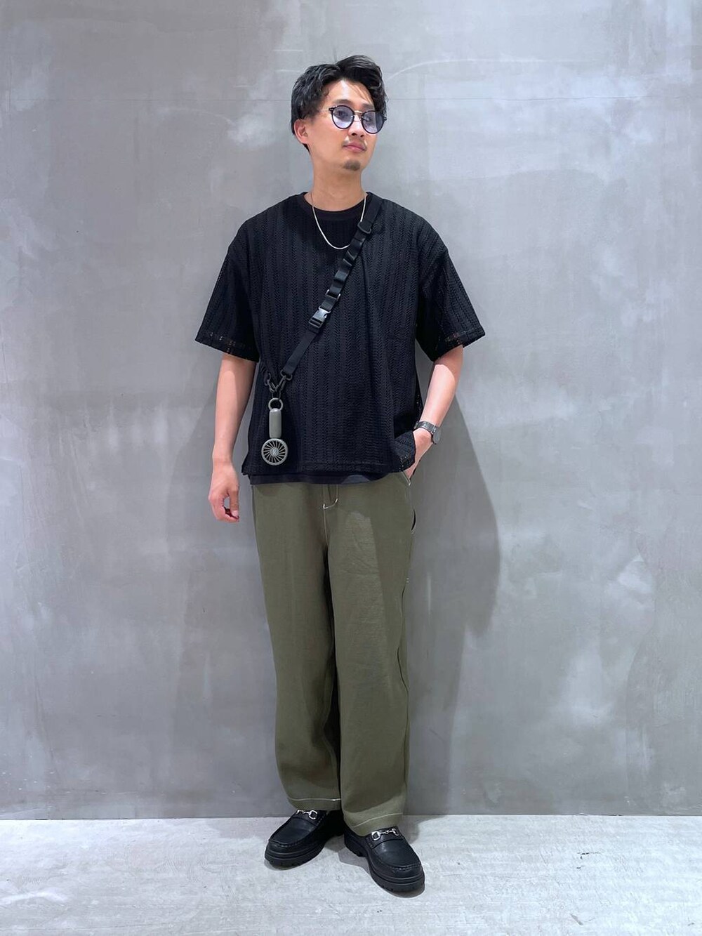 グリーン系のその他パンツ、ブラック系のローファー、ブラック系のTシャツ/カットソーを着用したメンズの春コーディネートの4枚目の写真