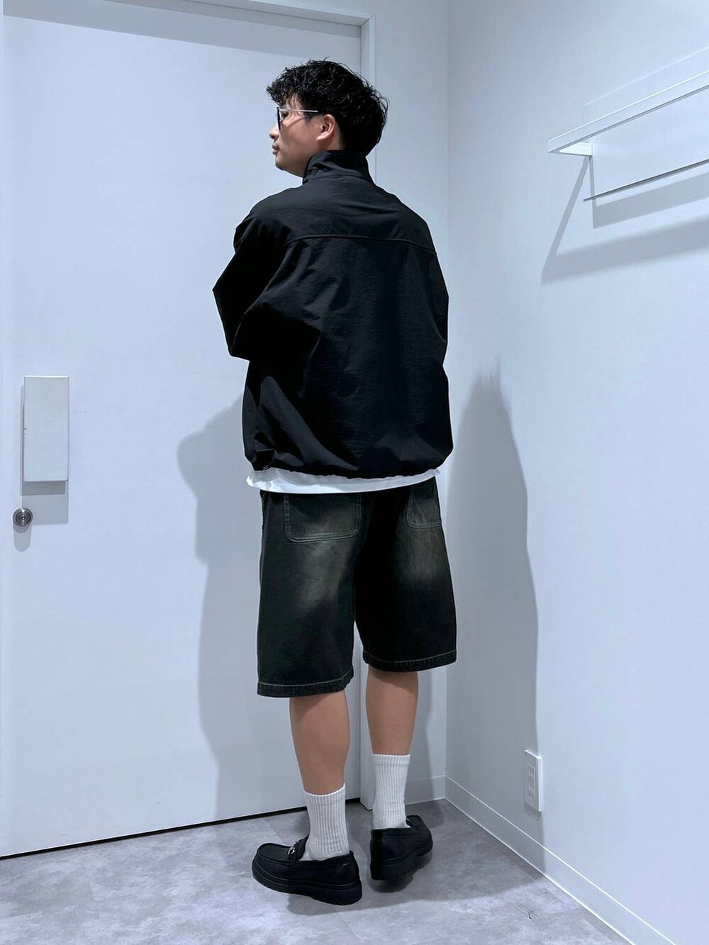 ブラック系のローファー、ブラック系のブルゾン、ブラック系のデニムパンツを着用したメンズの春コーディネートの3枚目の写真