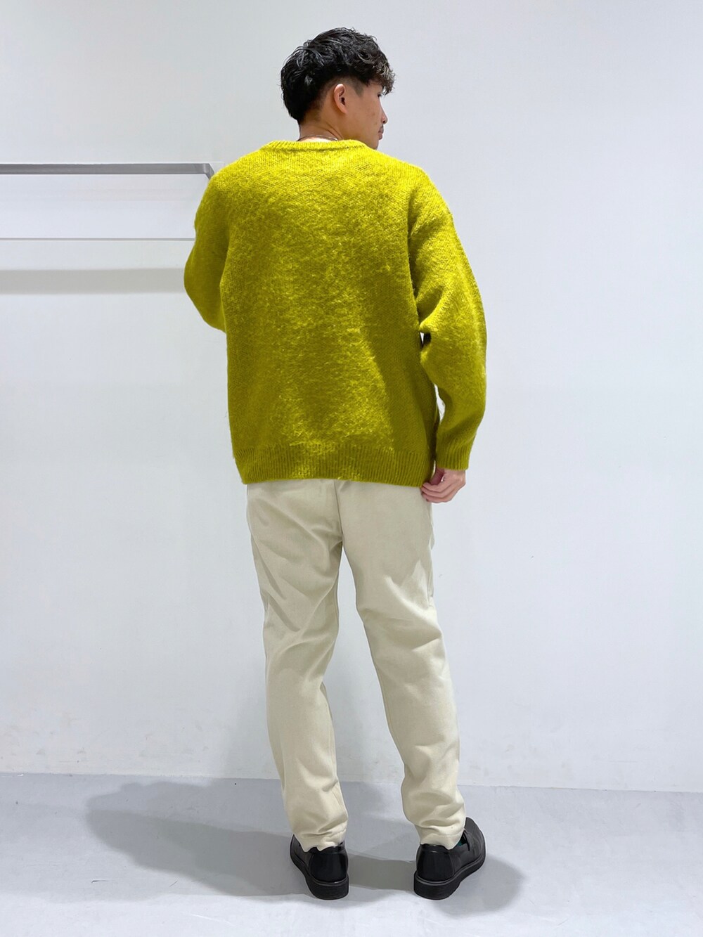 ホワイト系のその他パンツ、ブラック系のローファー、イエロー系のニット/セーターを着用したメンズの冬コーディネートの3枚目の写真