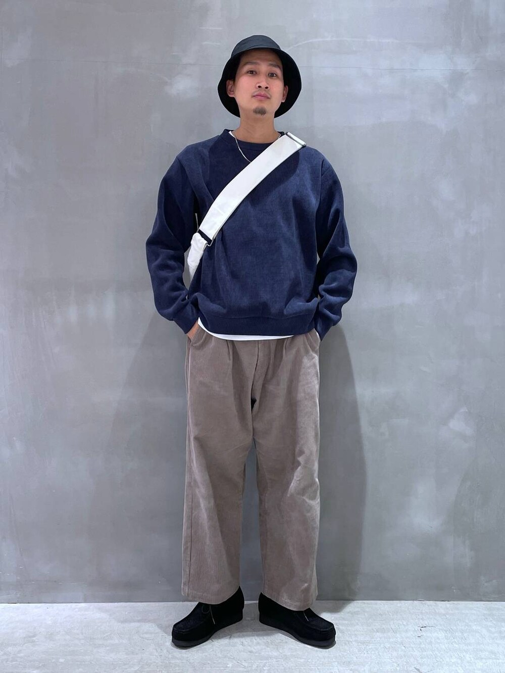 ベージュ系のショルダーバッグ、ベージュ系のその他パンツ、ブラック系のモカシン/デッキシューズを着用したメンズの冬コーディネートの4枚目の写真