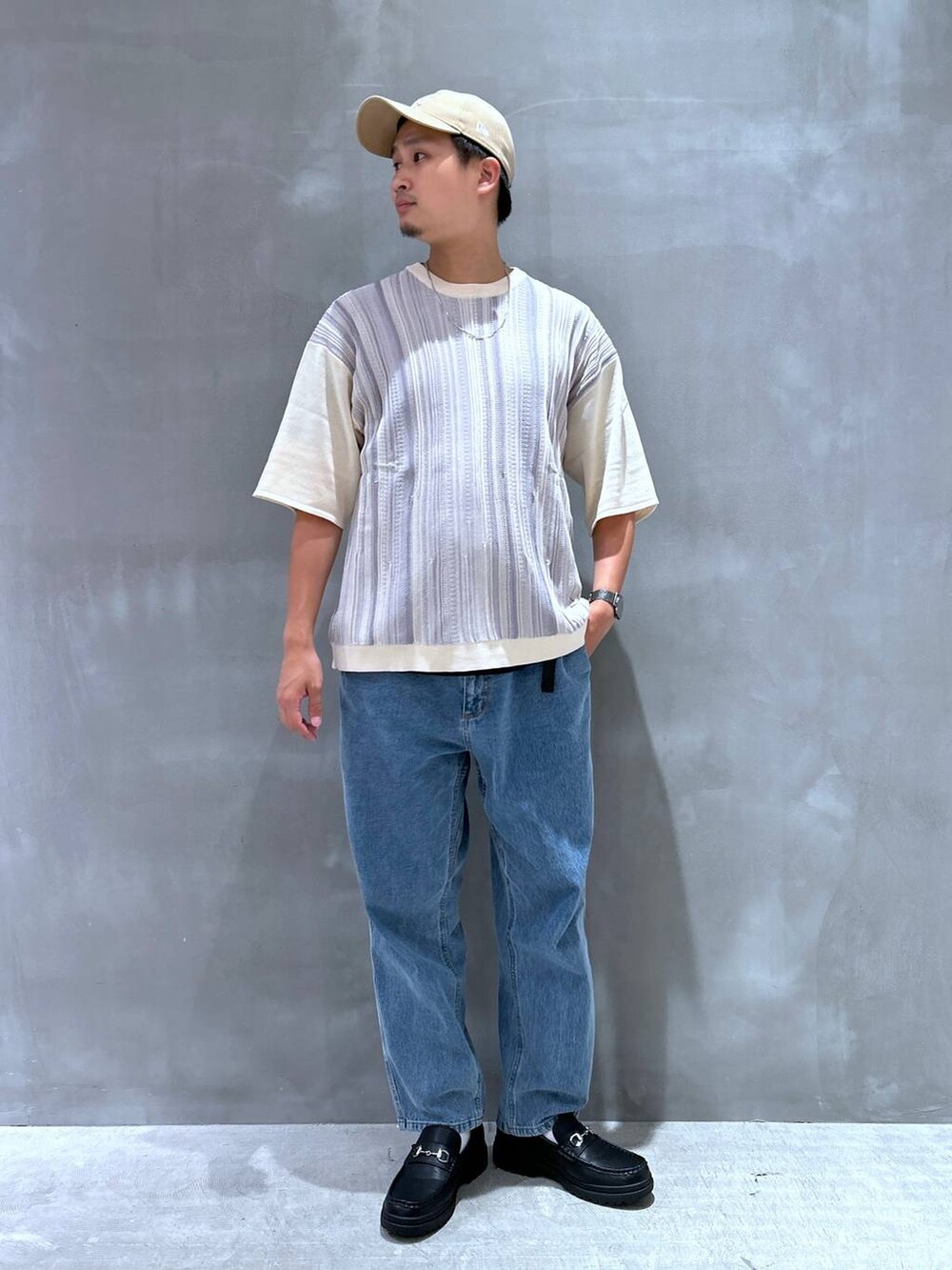 ブルー系のデニムパンツ、ブラック系のローファー、グレー系のニット/セーターを着用したメンズの夏コーディネートの2枚目の写真