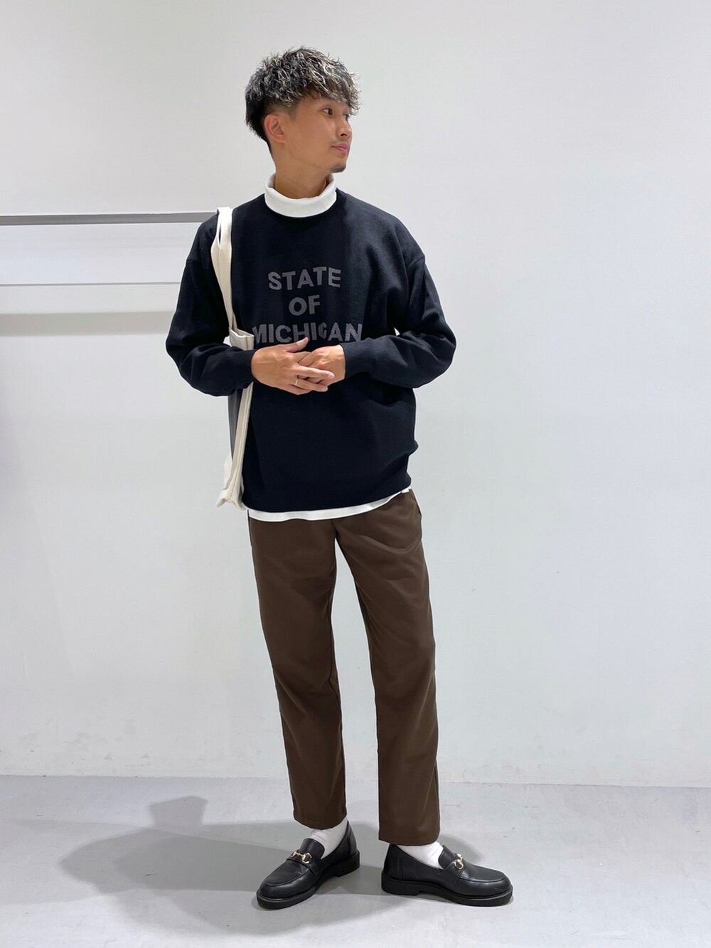 ブラック系のローファー、ホワイト系のTシャツ/カットソー、ブラウン系のスラックスを着用したメンズの冬コーディネートの3枚目の写真