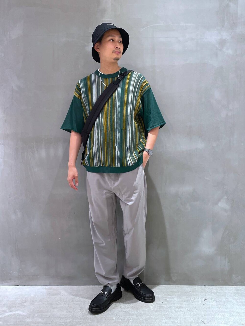 グレー系のTシャツ/カットソー、ブラック系のローファー、ブラック系のショルダーバッグを着用したメンズの夏コーディネートの3枚目の写真