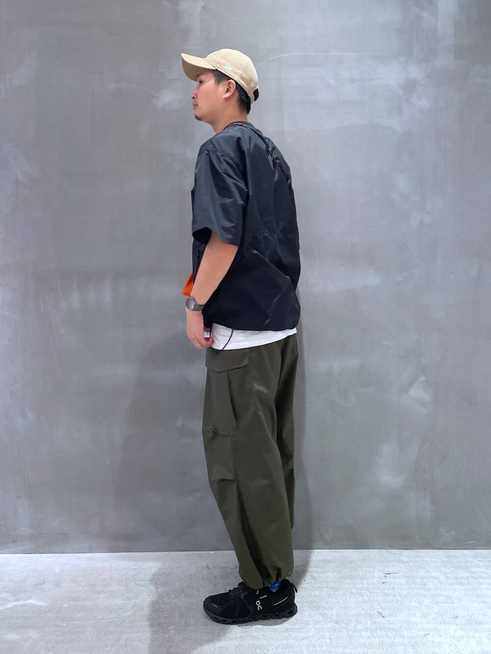 ホワイト系のTシャツ/カットソー、グリーン系のカーゴパンツ、オレンジ系のショルダーバッグを着用したメンズの夏コーディネートの3枚目の写真