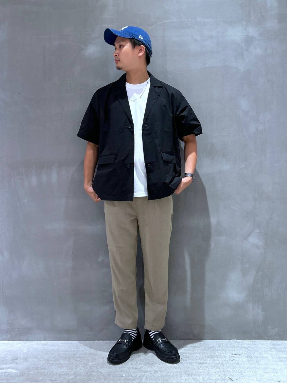 ホワイト系のTシャツ/カットソー、ブラック系のローファー、ベージュ系のその他パンツを着用したメンズの夏コーディネートの4枚目の写真