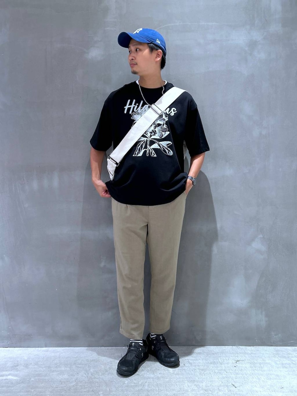 ベージュ系のショルダーバッグ、ベージュ系のその他パンツ、ブラック系のTシャツ/カットソーを着用したメンズの夏コーディネートの2枚目の写真