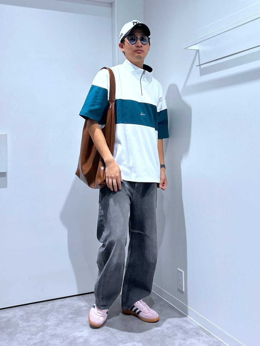 グレー系のデニムパンツ、グリーン系のTシャツ/カットソー、ブラウン系のトートバッグを着用したメンズの春コーディネートの4枚目の写真