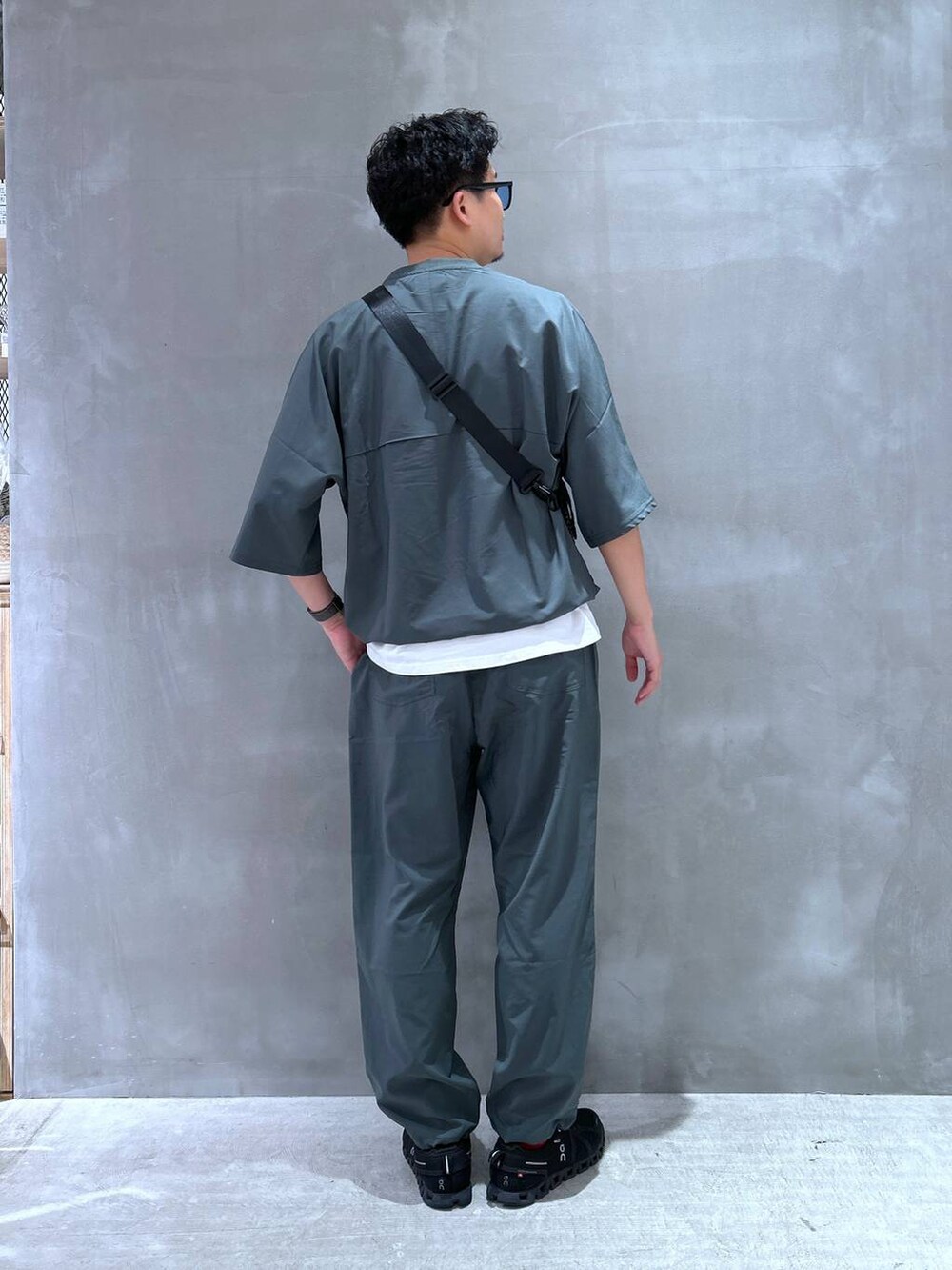 ブラック系のショルダーバッグ、ホワイト系のTシャツ/カットソー、グリーン系のTシャツ/カットソーを着用したメンズの夏コーディネートの2枚目の写真