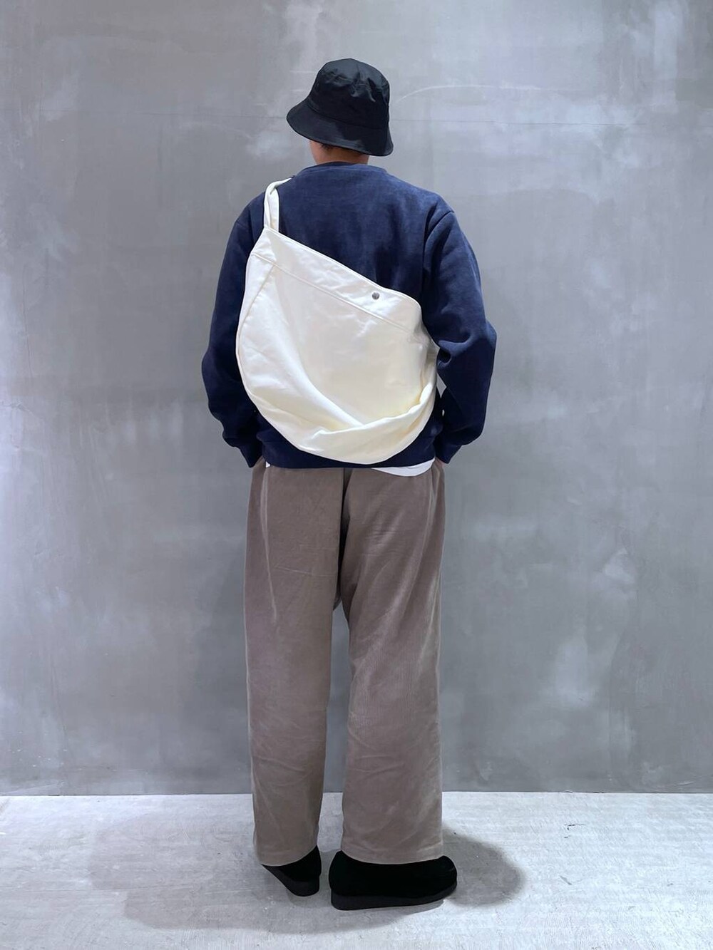 ベージュ系のショルダーバッグ、ベージュ系のその他パンツ、ブラック系のモカシン/デッキシューズを着用したメンズの冬コーディネートの3枚目の写真