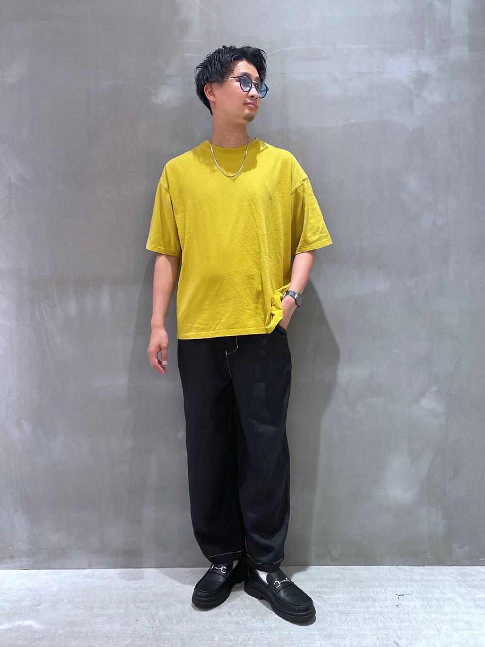 ブラック系のその他パンツ、ブラック系のローファー、イエロー系のTシャツ/カットソーを着用したメンズの春コーディネートの3枚目の写真