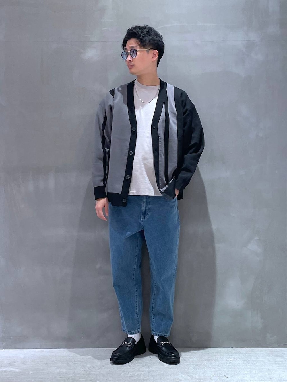 ブルー系のデニムパンツ、グレー系のTシャツ/カットソー、ブラック系のローファーを着用したメンズの春コーディネートの5枚目の写真