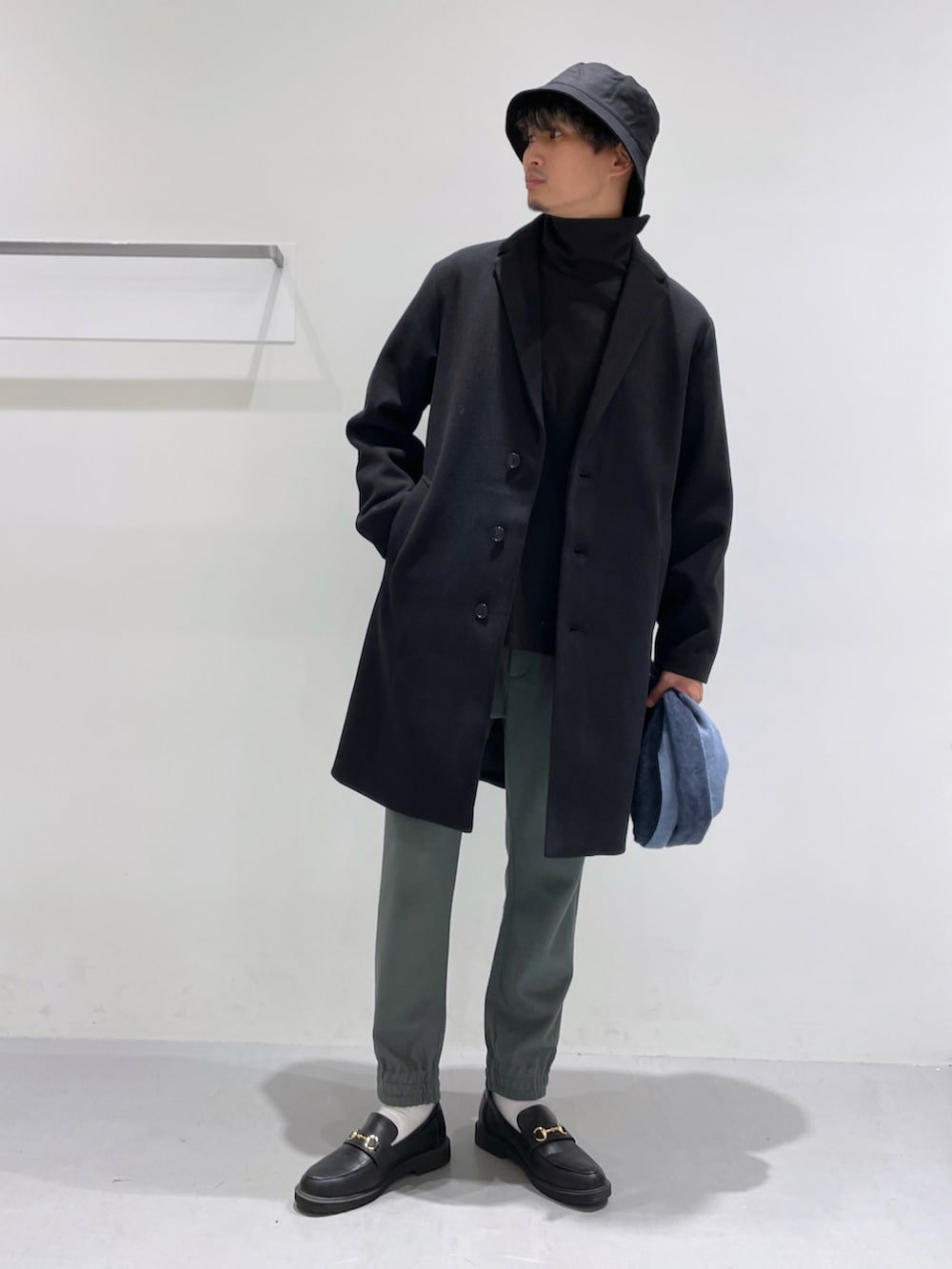 ブラック系のローファー、ブラック系のチェスターコート、ブラック系のTシャツ/カットソーを着用したメンズの冬コーディネートの3枚目の写真