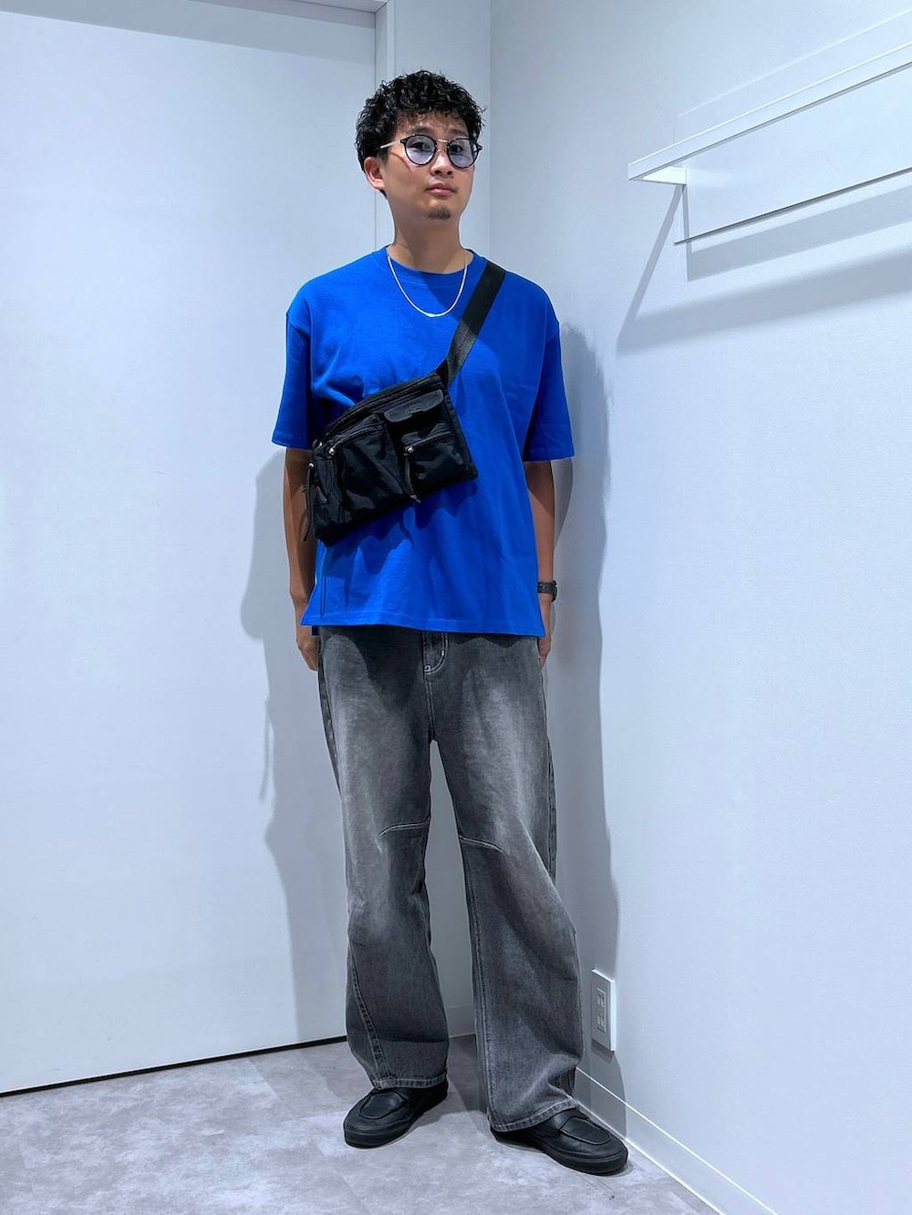 グレー系のデニムパンツ、ブラック系のボディバッグ/ウエストポーチ、ブラック系のサングラスを着用したメンズの春コーディネートの3枚目の写真