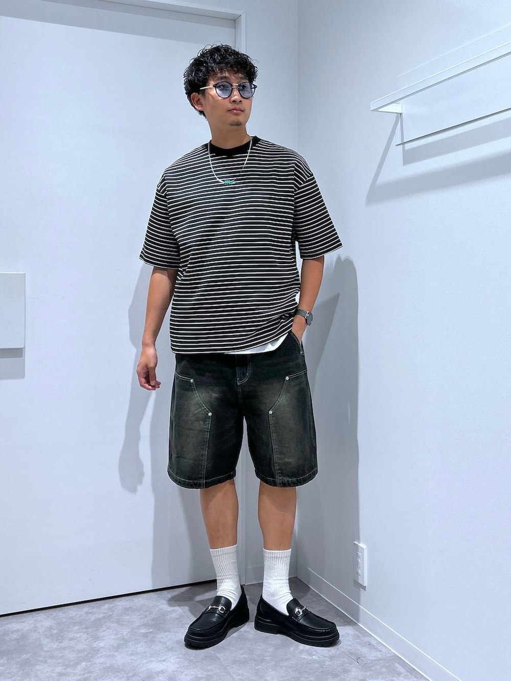 ブラック系のローファー、ブラック系のデニムパンツ、その他のTシャツ/カットソーを着用したメンズの春コーディネートの4枚目の写真