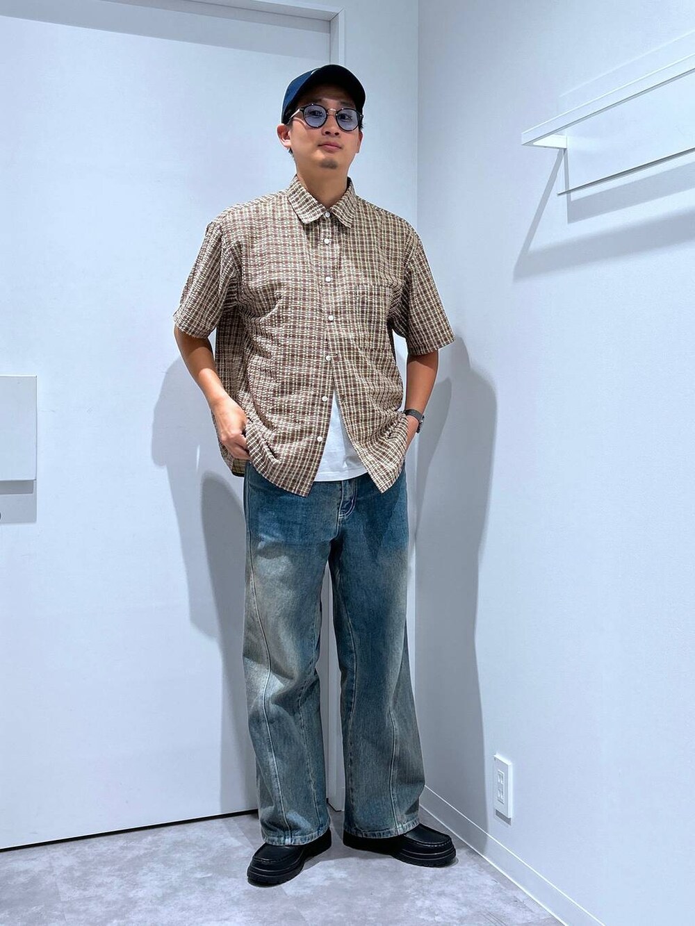 ブルー系のデニムパンツ、ブラック系のローファー、レッド系のシャツ/ブラウスを着用したメンズの春コーディネートの2枚目の写真