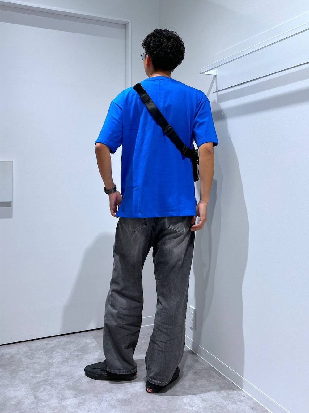 グレー系のデニムパンツ、ブラック系のボディバッグ/ウエストポーチ、ブラック系のサングラスを着用したメンズの春コーディネートの2枚目の写真