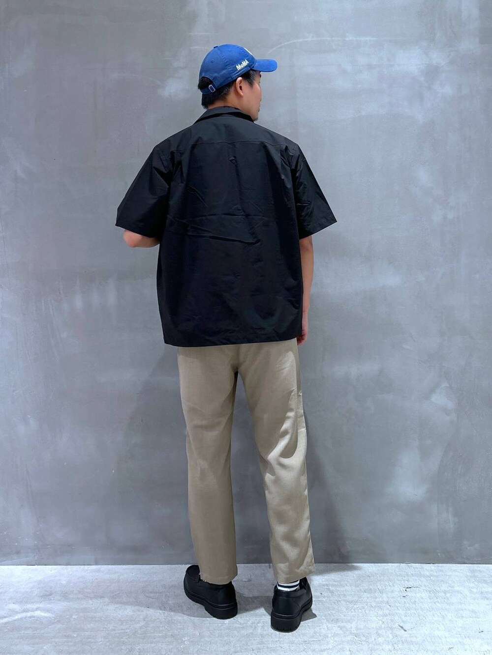 ホワイト系のTシャツ/カットソー、ブラック系のローファー、ベージュ系のその他パンツを着用したメンズの夏コーディネートの3枚目の写真