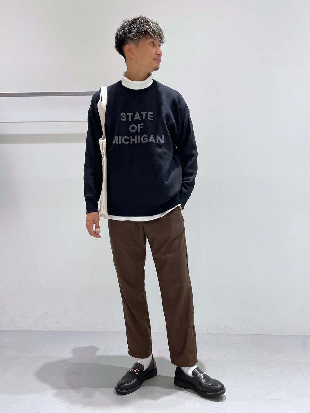 ブラック系のローファー、ホワイト系のTシャツ/カットソー、ブラウン系のスラックスを着用したメンズの冬コーディネートの4枚目の写真