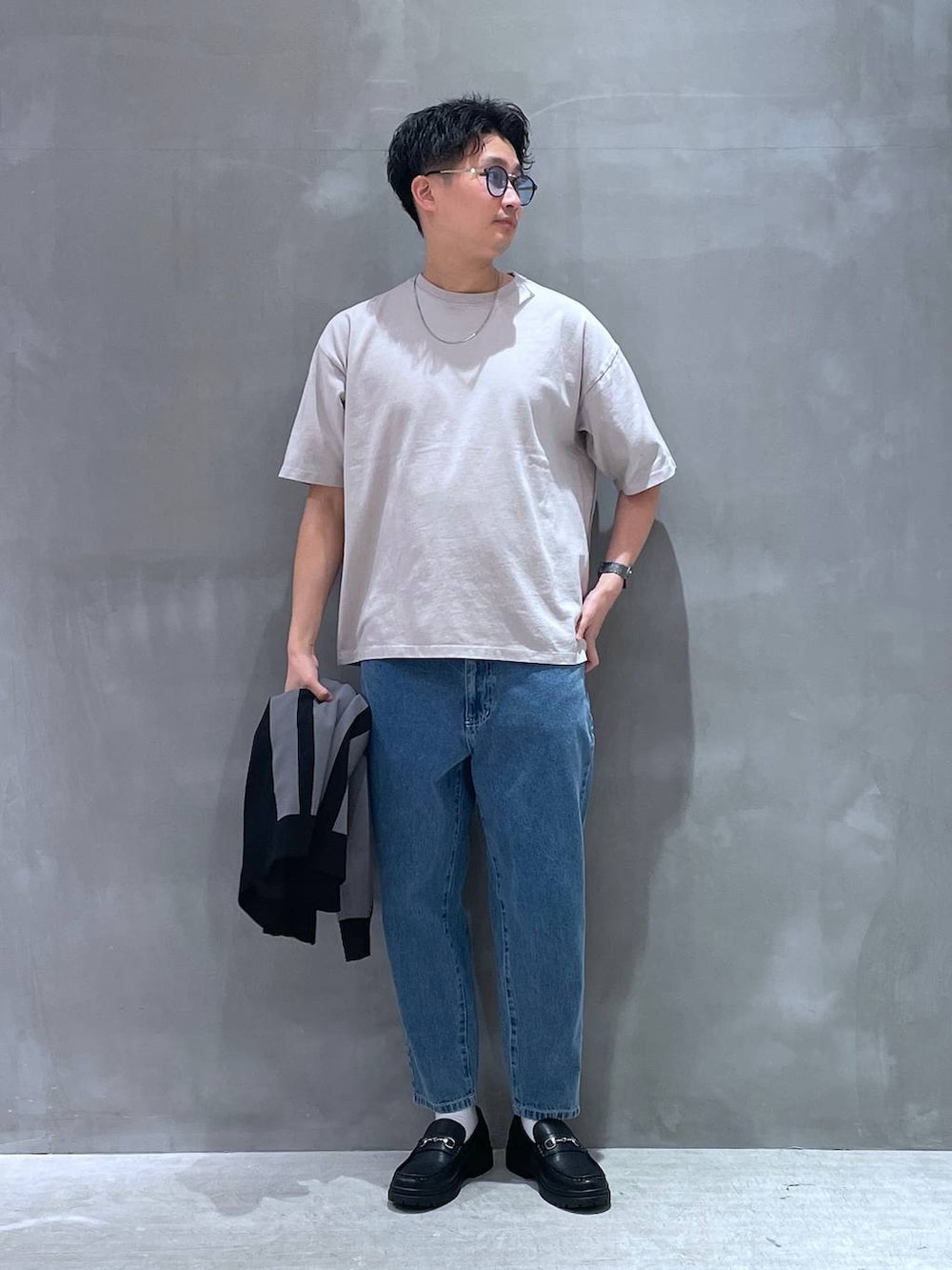 ブルー系のデニムパンツ、グレー系のTシャツ/カットソー、ブラック系のローファーを着用したメンズの春コーディネートの3枚目の写真