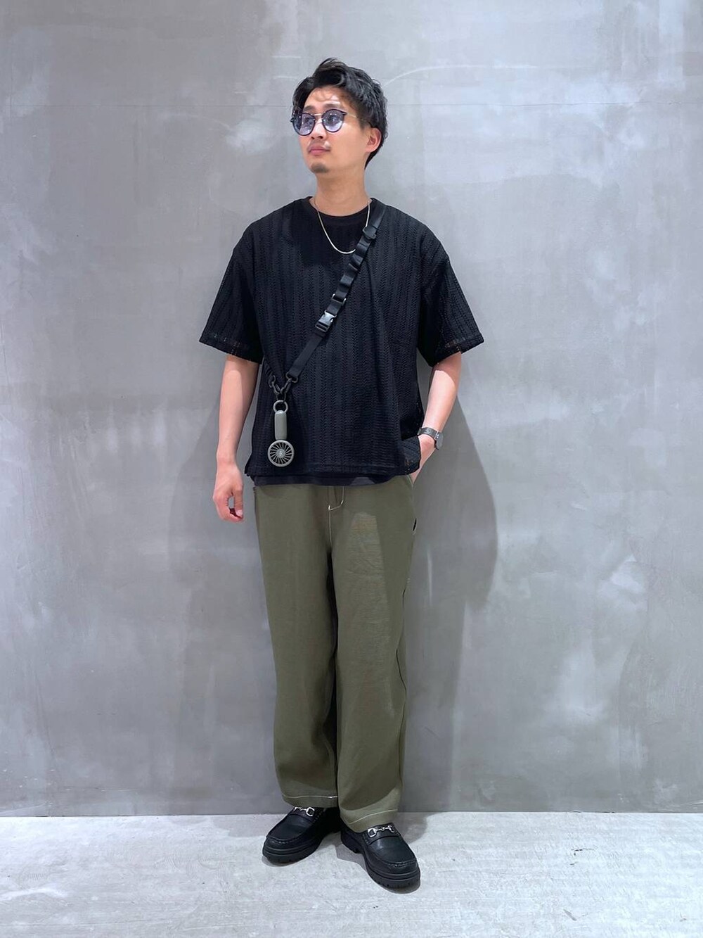 グリーン系のその他パンツ、ブラック系のローファー、ブラック系のTシャツ/カットソーを着用したメンズの春コーディネートの2枚目の写真