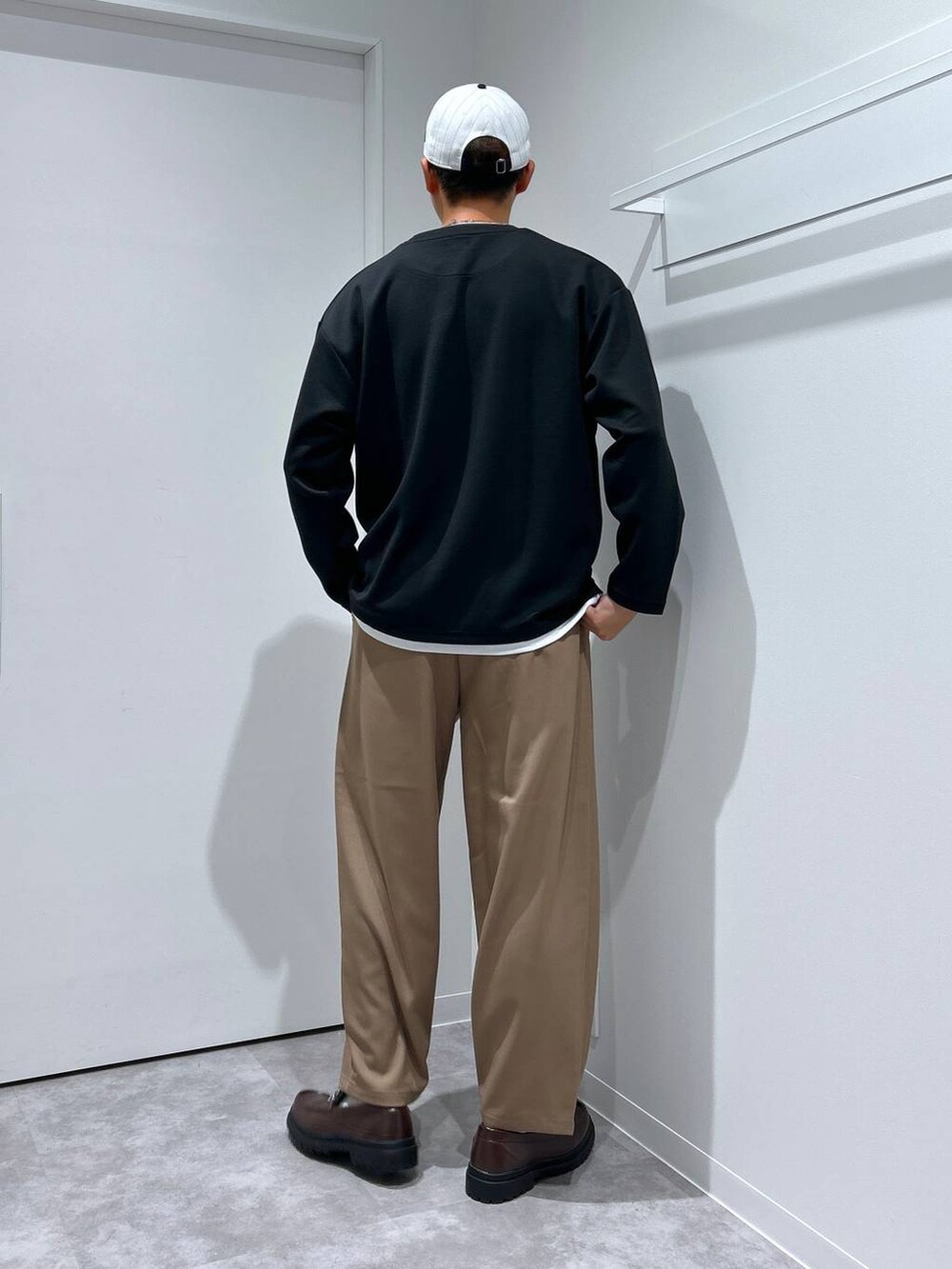 ブラック系のTシャツ/カットソー、ブラウン系のローファー、グリーン系のサングラスを着用したメンズの冬コーディネートの3枚目の写真