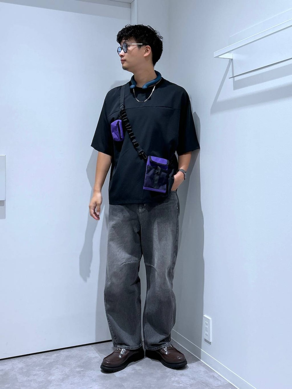 グレー系のデニムパンツ、ブラウン系のローファー、パープル系のショルダーバッグを着用したメンズの春コーディネートの4枚目の写真