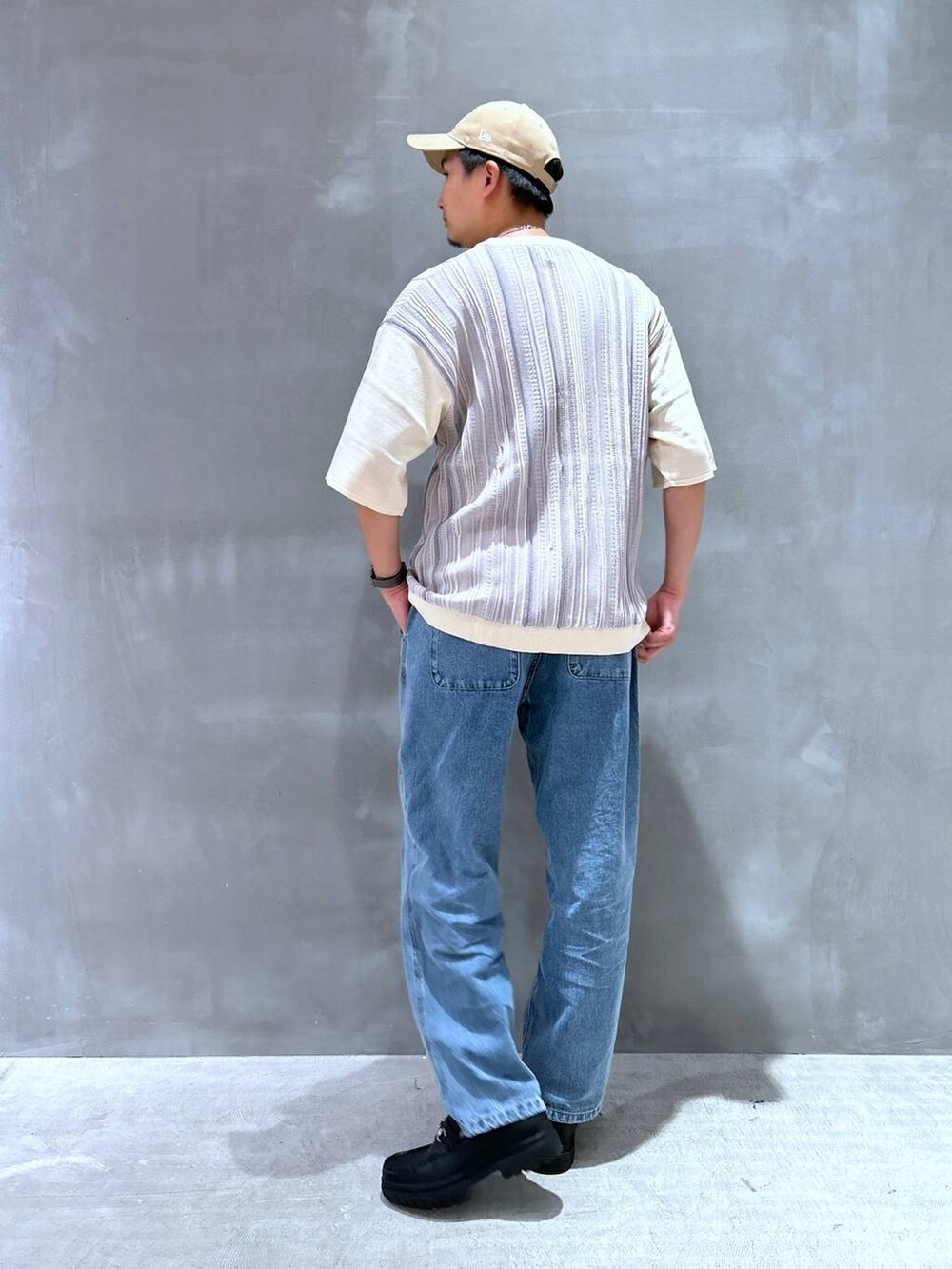 ブルー系のデニムパンツ、ブラック系のローファー、グレー系のニット/セーターを着用したメンズの夏コーディネートの3枚目の写真