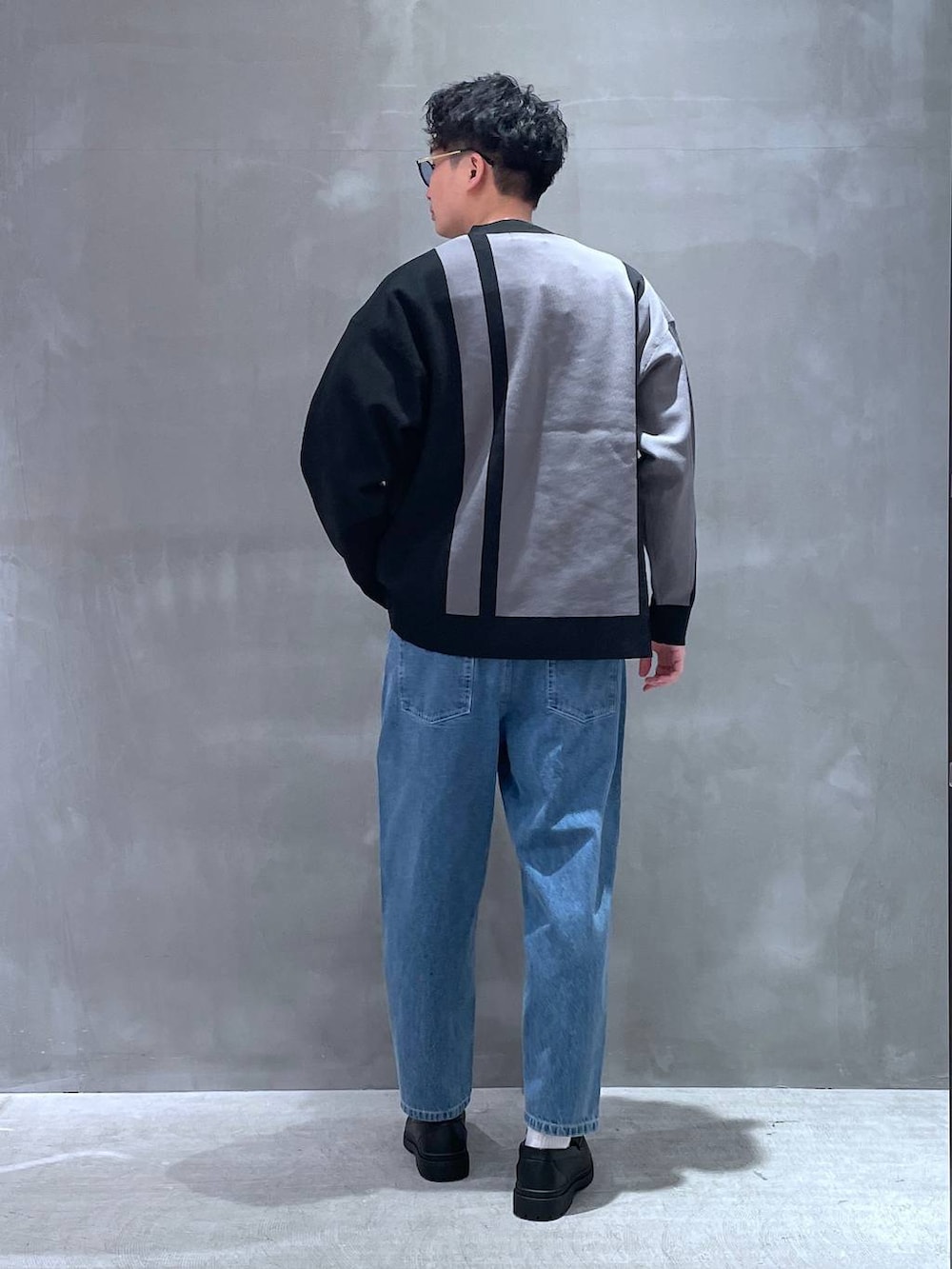 ブルー系のデニムパンツ、グレー系のTシャツ/カットソー、ブラック系のローファーを着用したメンズの春コーディネートの4枚目の写真