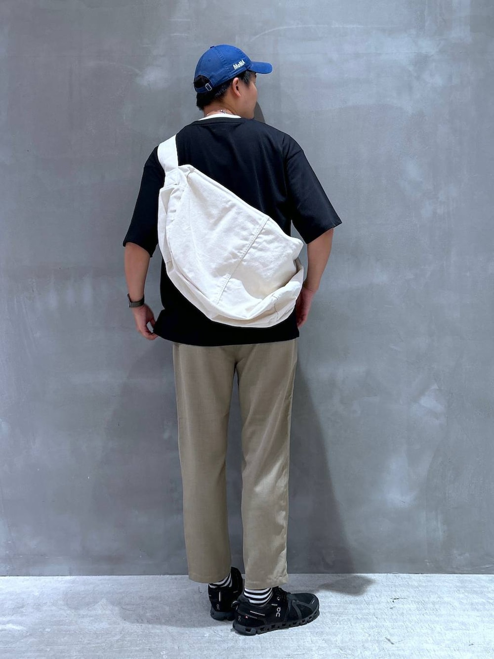ベージュ系のショルダーバッグ、ベージュ系のその他パンツ、ブラック系のTシャツ/カットソーを着用したメンズの夏コーディネートの3枚目の写真